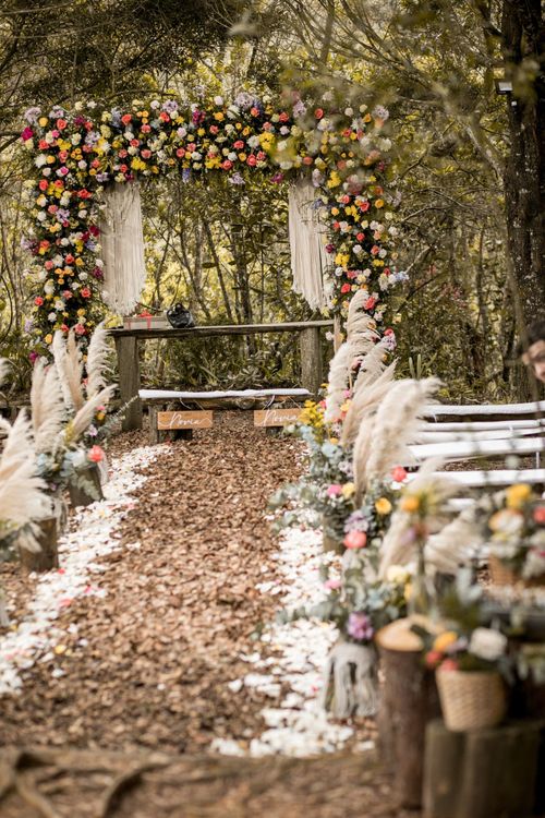 Arco floral y pasillo de la ceremonia en el bosque